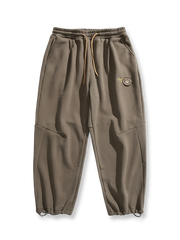 製品画像: 4色展開 カジュアル スウェットパンツ。裏起毛素材とルーズフィットデザインを採用した、冬に最適な厚手スウェットパンツの正面全体展示図。

詳細画像: 柔らかい裏起毛素材の質感と、冷気を防ぐ裾のリブデザインのディテールクローズアップ。