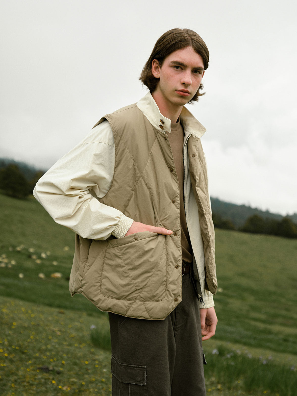 詳細画像: ダイヤキルティングデザインと撥水加工素材のディテール展示 - 冬のアウターに最適なスタイリッシュなデザイン。

モデル画像: モデル着用のレイヤードスタイルのダウンベスト - アウトドアやデイリーコーデにぴったりの万能アイテム。