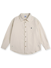 製品画像
ウォッシュ加工が施されたヴィンテージ感あふれるシャツ全体図。柔らかな生地の質感とココナッツ製ボタンの自然な風合いが際立つデザインで、ネイティブアメリカンのトーテム刺繍がアクセント

詳細画像
天然のココナッツ製ボタンと、背面に丁寧に施されたインディアンテントモチーフのトーテム刺繍のディテール。ウォッシュ加工による独特のヴィンテージ感と、18針/3cmの高密度縫製が美しい仕上がりを実現