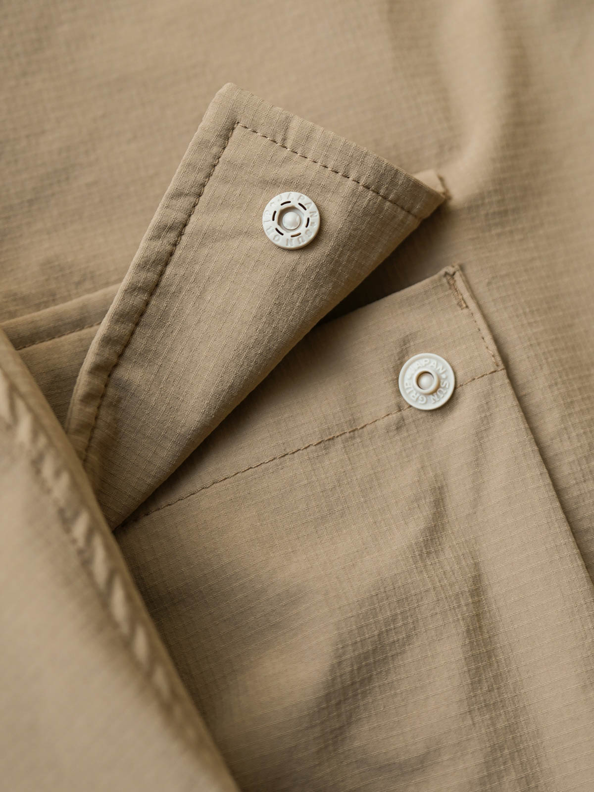 製品画像:
「ペイズリー柄 パッチワーク レイヤード風 長袖シャツの全体展示図。機能性ナイロン素材とヴィンテージ感あるペイズリー柄のパッチワークを融合し、レイヤード風デザインで深みと個性を加えたシャツ。大容量ポケットと高品質スナップボタンが実用性を提供。」

詳細画像:
「裾部分のペイズリー柄パッチワークと立体的な大容量ポケットのディテール特写。レイヤード風デザインとともに、視覚的な深さと柔らかさを加え、機能性とファッション性を兼ね備えたデザイン。」
