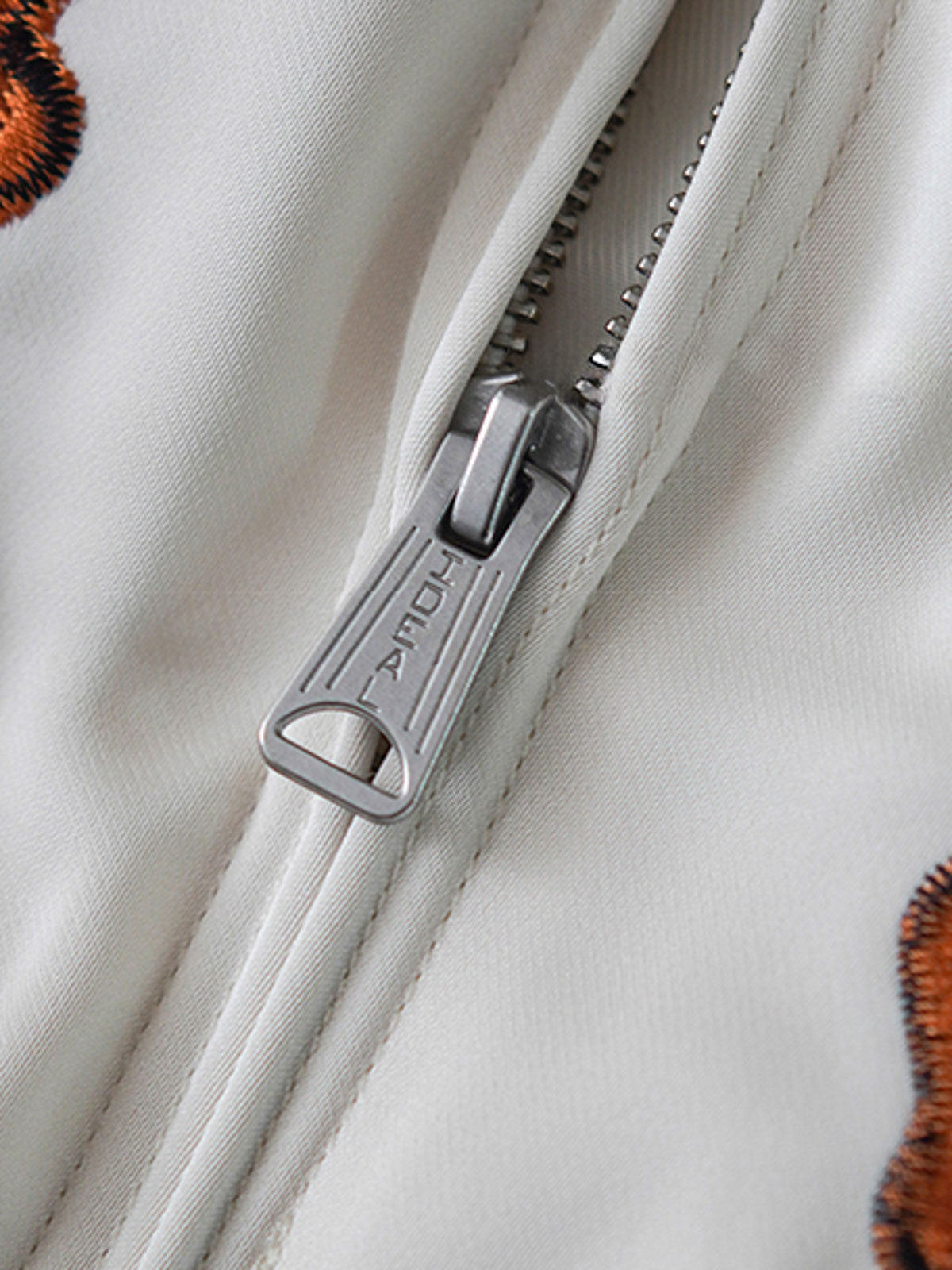  ジャケットのディテールショット、高級ポリエステル素材と美しい刺繍工芸を展示