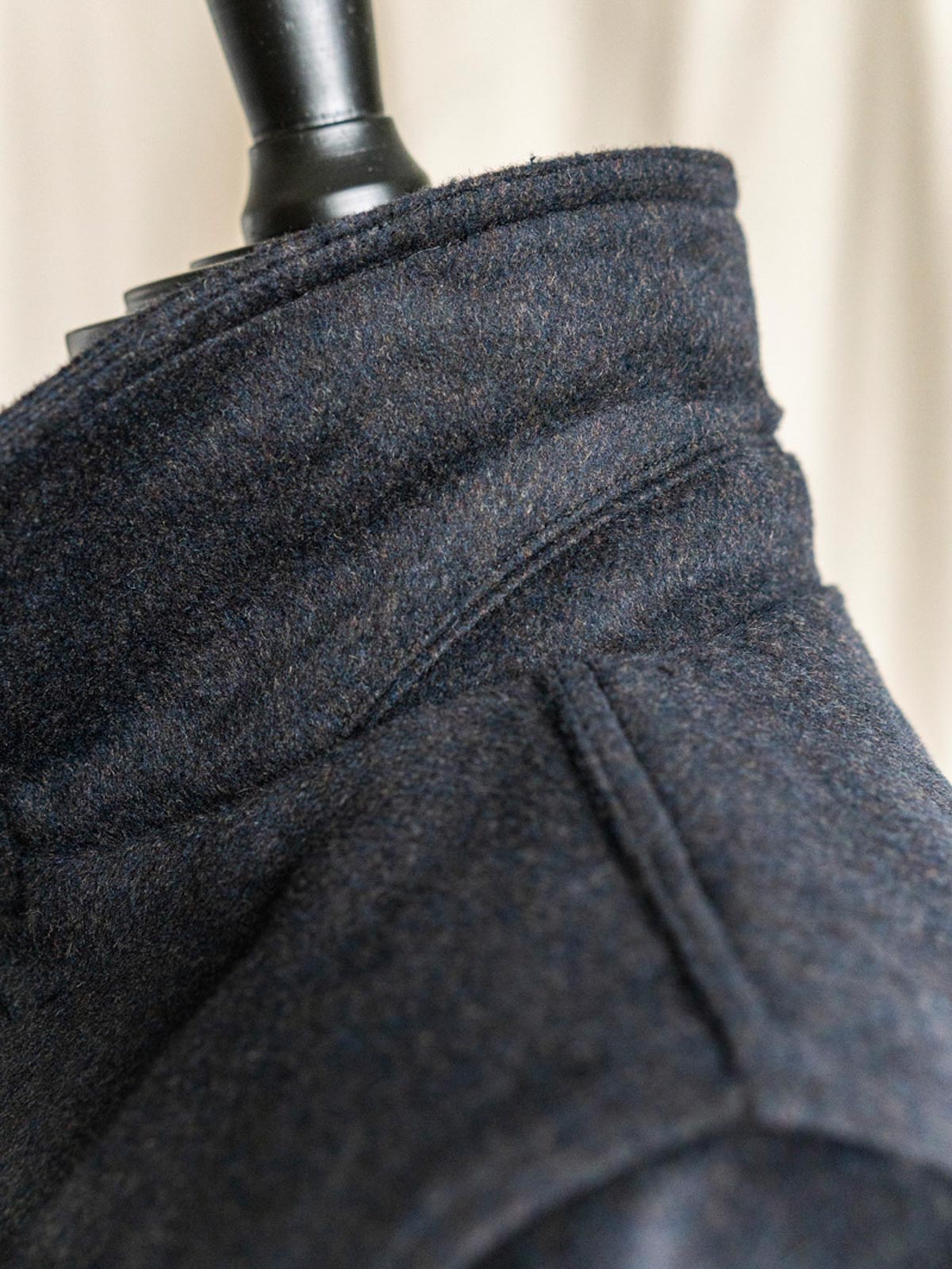 コートのディテールショット、ビンテージボタンとツイード生地の細部を展示