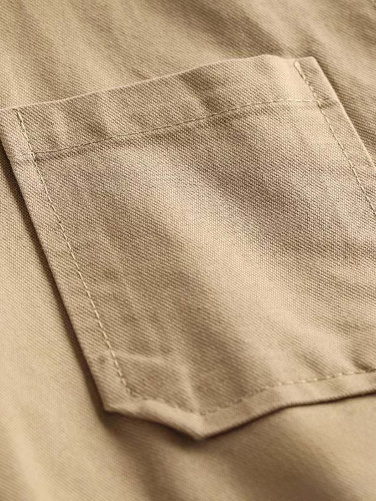 製品画像: ヴィンテージサイクリングベストの正面全体画像。
詳細画像: 多機能ポケットとVネックのヴィンテージボタンディテールのクローズアップ。