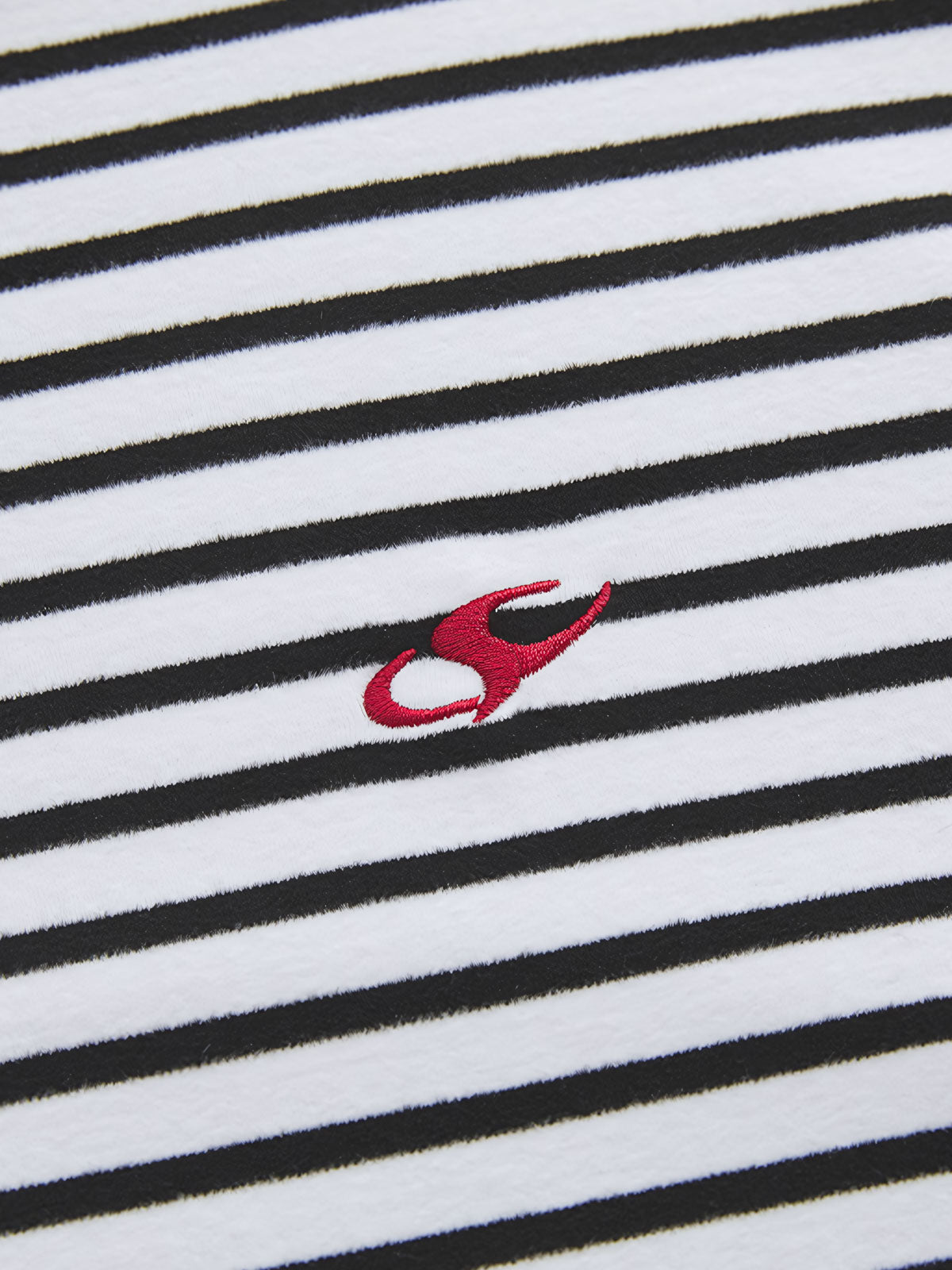 製品画像: 自発熱機能を持つデロン素材のストライプインナーの正面ビュー
詳細画像: モックネックデザインと刺繍ディテールの表示