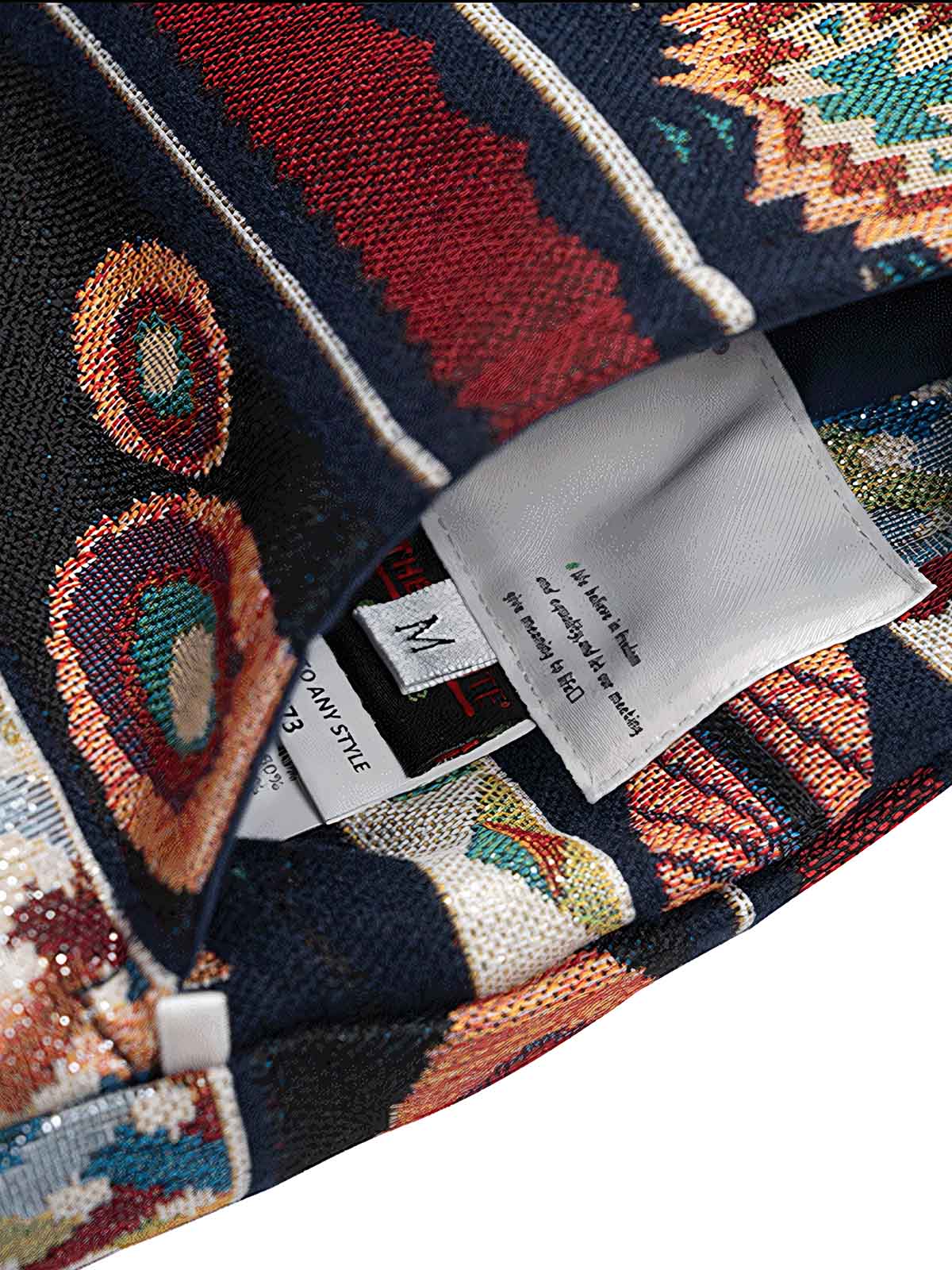 製品画像: THERMLLITEテクノロジーコットン使用のリバーシブルヴィンテージジャカードベストの正面図。高密度パールキャンバスとリブジャカードの両面デザインが特徴。
詳細画像: ヴィンテージジャカード内側とクラシックなフラワーボタンのディテールクローズアップ。THERMLLITE中綿で保温性を強化。