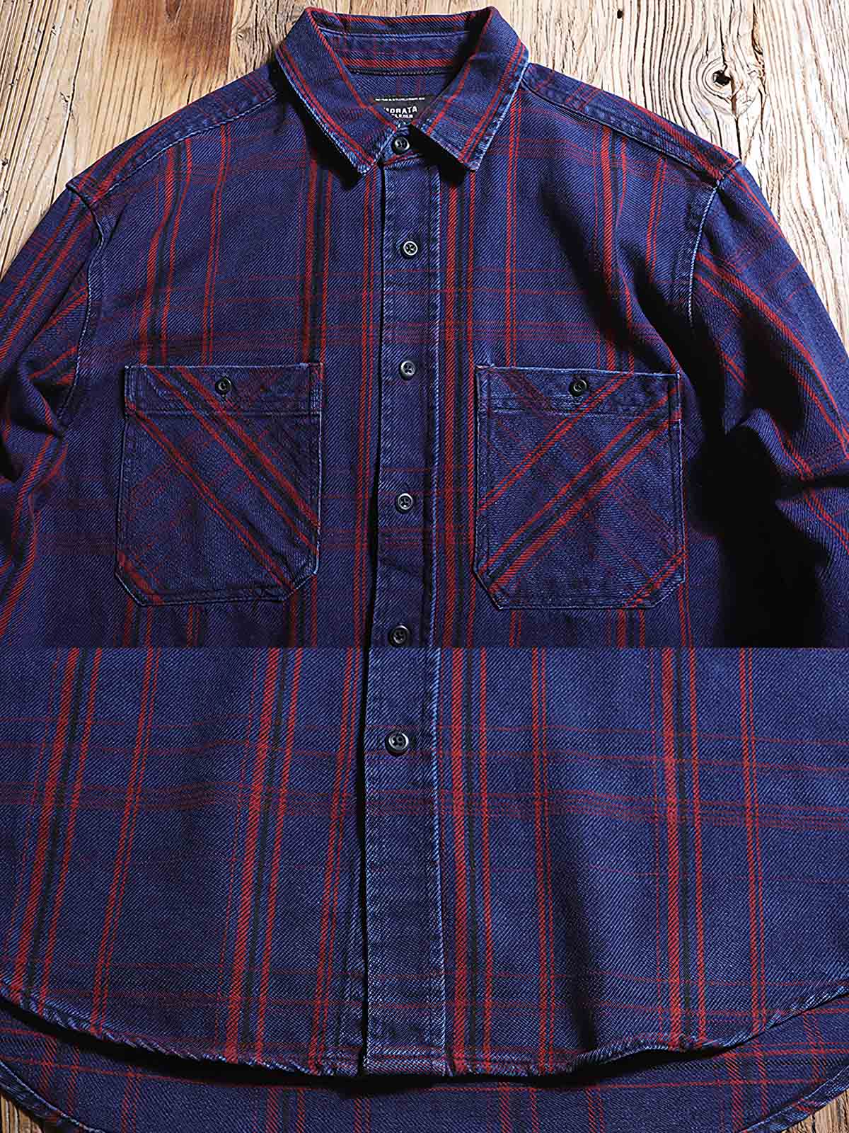 製品画像: ワークレトロチェック柄シャツの正面画像。厚手のコットン100%素材で作られた、ヴィンテージスタイルのクラシックシャツ。
詳細画像: ヴィンテージボタンと耐久性のあるチェック柄コットン生地のディテール特写。レトロなワークスタイルを演出。