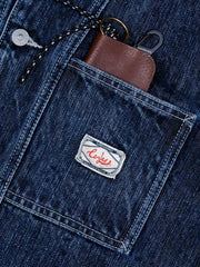 詳細画像: 竹節のテクスチャーとダブルレイヤーポケットのディテール特写
モデル画像: モデルが着用したクラシックデニムブルーのワークデニムジャケット、ハードでヴィンテージ感漂うスタイル