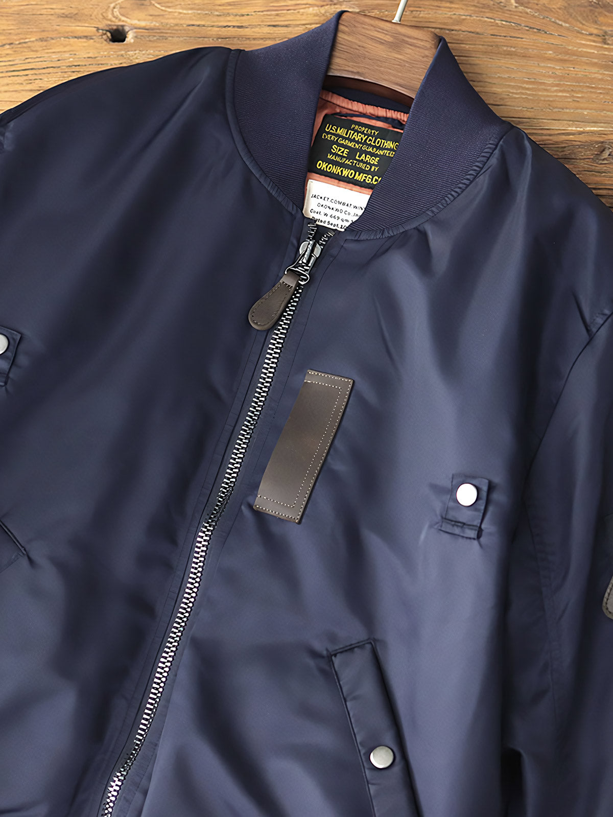 製品画像: MA-1 撥水性 厚手 フライトジャケット 正面、レトロなデザインと実用性
詳細画像: TALON No.10ジッパーとシグネチャースリーブポケットのディテール、耐久性と高級感