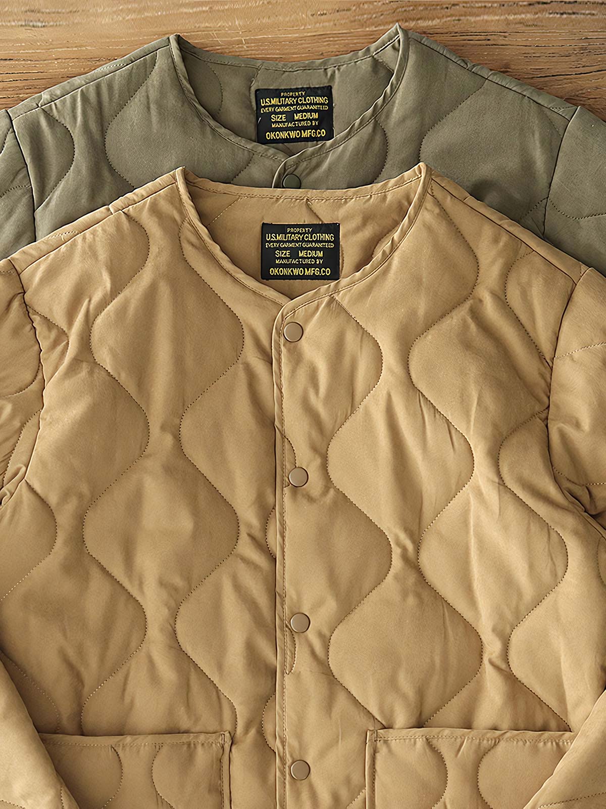 製品画像: M65ライナーリニューアルコートの全体展示。柔らかな両面ピーチスキンとウォッシュドコットン中綿を使用し、秋冬のアウターに最適な暖かさと快適さを提供するノーカラーデザイン。
詳細画像: 独特なウェーブキルティングディテールが施されたM65ライナーコート、シワになりにくいピーチスキン素材の質感。