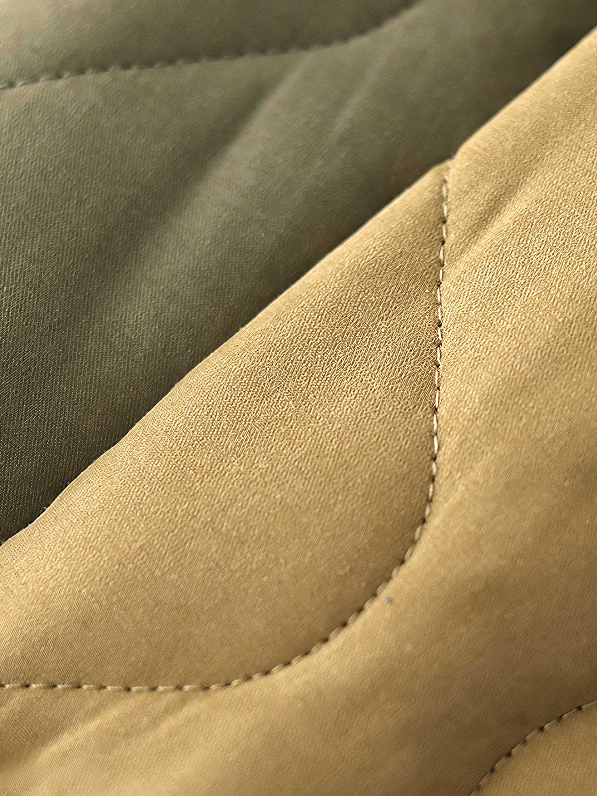 製品画像: M65ライナーリニューアルコートの全体展示。柔らかな両面ピーチスキンとウォッシュドコットン中綿を使用し、秋冬のアウターに最適な暖かさと快適さを提供するノーカラーデザイン。
詳細画像: 独特なウェーブキルティングディテールが施されたM65ライナーコート、シワになりにくいピーチスキン素材の質感。