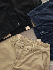 製品画像：アメリカンクラシックストレートツイルパンツの正面図。クラシックなワークスタイルとカジュアル感が共存し、三季節に適した全コットン素材のアイテム。
詳細画像：後ろポケットに施されたフラップデザインのディテールを強調したクローズアップ画像。ワークテイストと実用性を兼ね備えたスタイル。