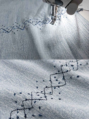 製品画像: ウォッシュ刺し子ストライプスタンドカラーデニムシャツ全体表示。東洋風デザインとモダンな刺し子刺繍が特徴のカジュアルシャツ。

詳細画像: ストライプ状の刺し子刺繍ディテール表示。民族風と幾何学模様が融合したデザインで、シャツのアクセントに。