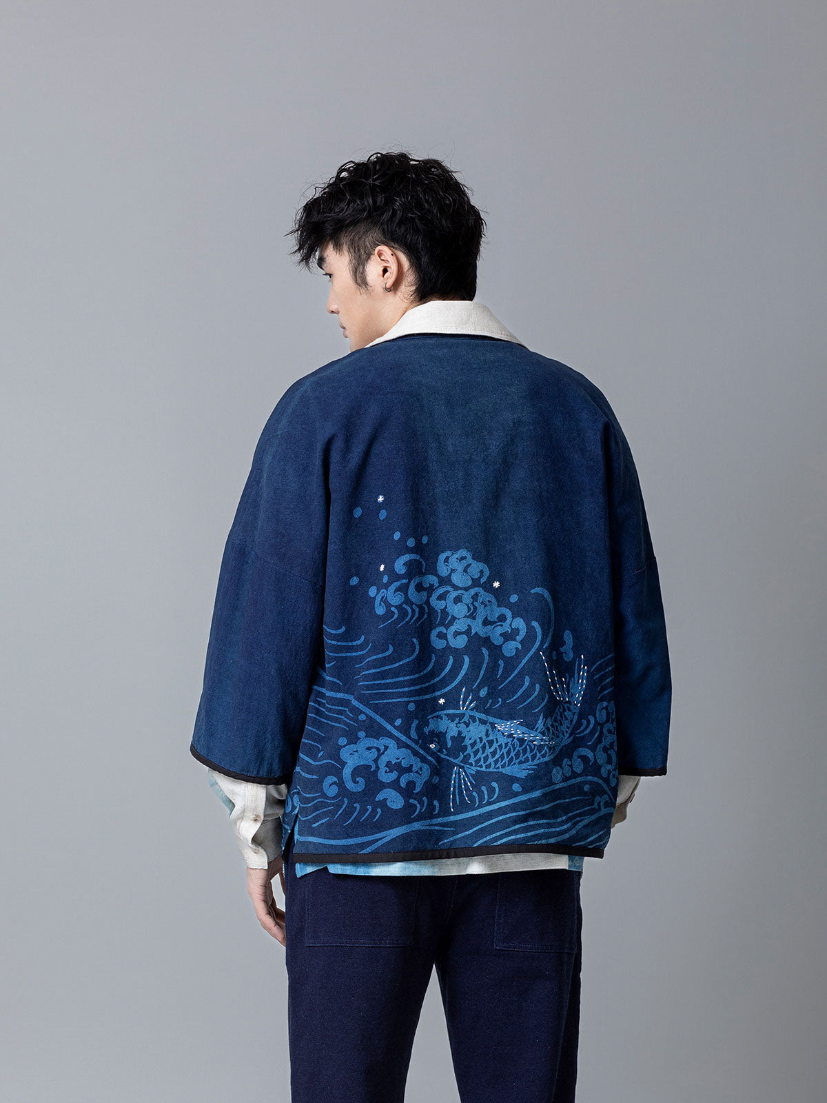 詳細画像：和柄の抜染と段落ち抜染のディテールをクローズアップ。刺し子刺繍と織り帯のディテールが、工芸的な価値を引き立てる。
モデル画像：モデルがリネンはんてんを着用。リネンパンツと合わせた品のあるカジュアルスタイルを提案。