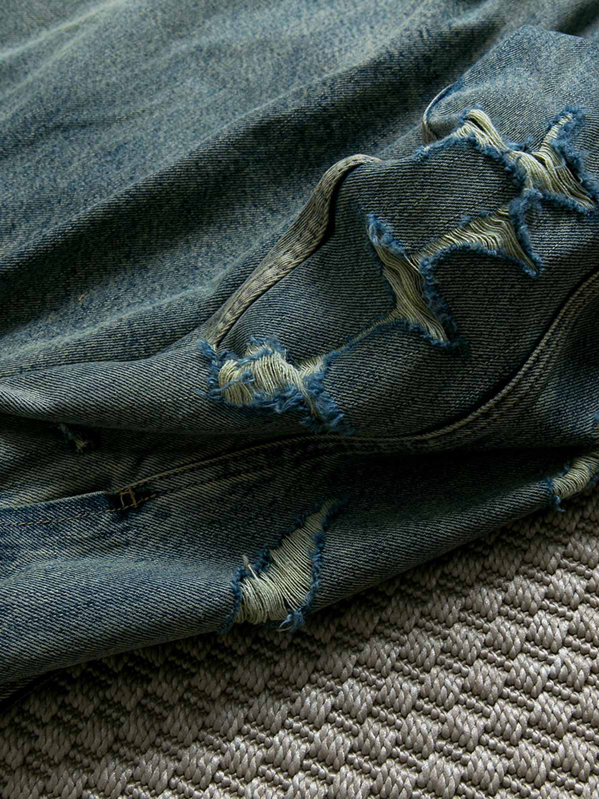 製品画像: ヴィンテージ風ダメージデニムジャケット全体表示。クラシックなチェック柄裏地とヘビーウェイトのコットン素材が特徴で、ワーク風シルエットが際立ちます。

詳細画像: ダメージ加工とチェック裏地のディテール表示。リアルなユーズド感とレイヤード効果がヴィンテージスタイルに深みを与えます。