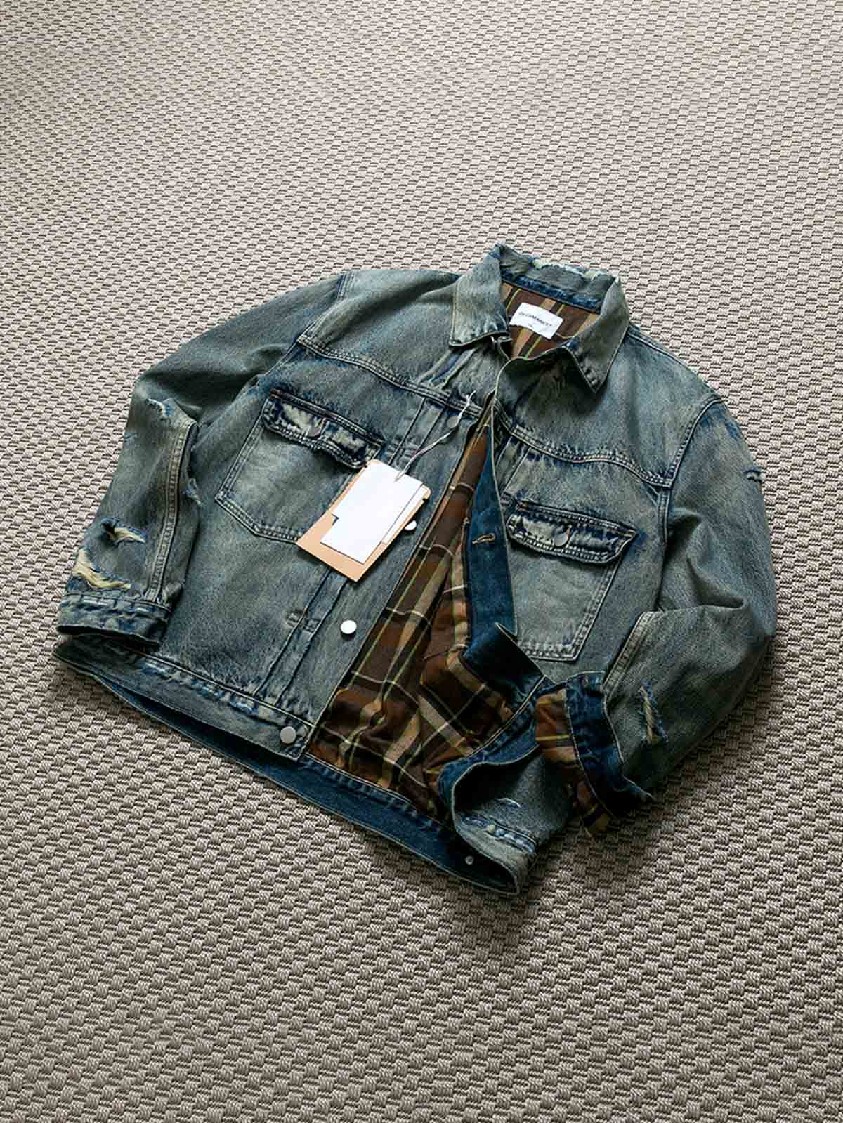 製品画像: ヴィンテージ風ダメージデニムジャケット全体表示。クラシックなチェック柄裏地とヘビーウェイトのコットン素材が特徴で、ワーク風シルエットが際立ちます。

詳細画像: ダメージ加工とチェック裏地のディテール表示。リアルなユーズド感とレイヤード効果がヴィンテージスタイルに深みを与えます。