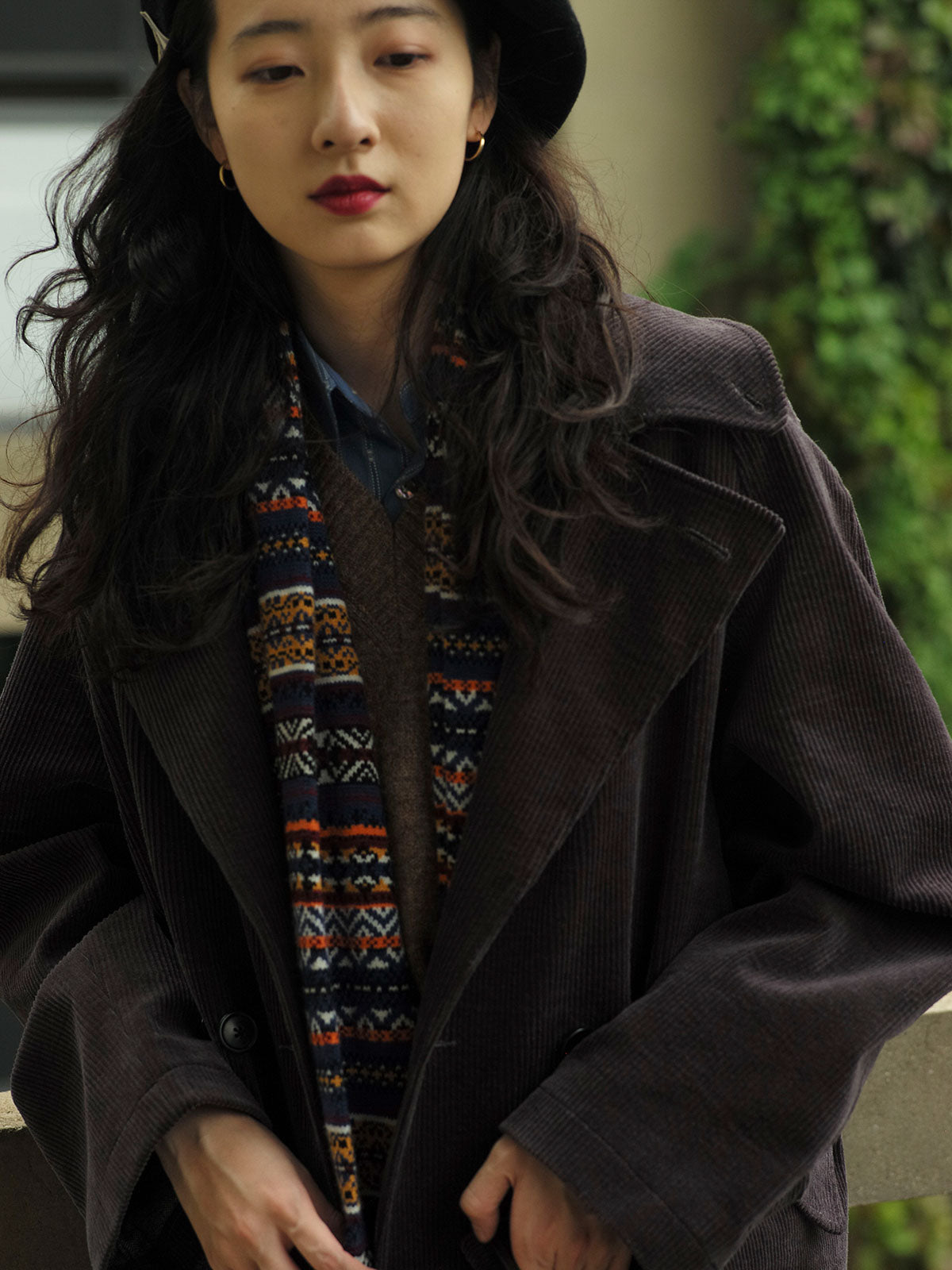 詳細画像：マフラーの織り目とフェアアイランド柄のディテールが鮮明に描かれており、シェトランドウール特有の柔らかな質感と耐久性が伝わります。染色技術にこだわったカラフルな糸が、アクセントとなる美しいデザインを際立たせています。

モデル画像：シェトランドウールのフェアアイランド柄マフラーを着用したモデルが、ヴィンテージ感のあるスタイルでコーディネートしています。マフラーの柔らかさと温かさが際立ち、日常的なカジュアルスタイルにもぴったりのアイテムであることを示しています。