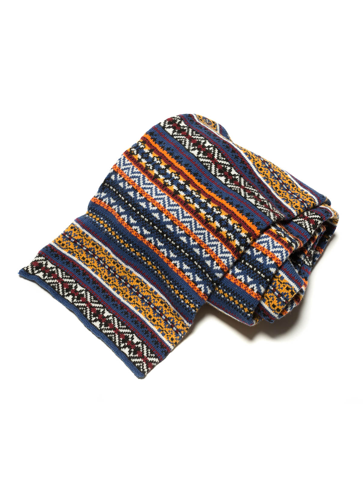 製品画像：シェトランドウールを使用したフェアアイランド柄マフラーの全体展示。柔らかな手触りと洗練されたデザインが特徴で、ヴィンテージ感溢れる編み模様と豊かなカラーリングが魅力的です。

詳細画像：マフラーの織り目とフェアアイランド柄のディテールが鮮明に描かれており、シェトランドウール特有の柔らかな質感と耐久性が伝わります。染色技術にこだわったカラフルな糸が、アクセントとなる美しいデザインを際立たせています。