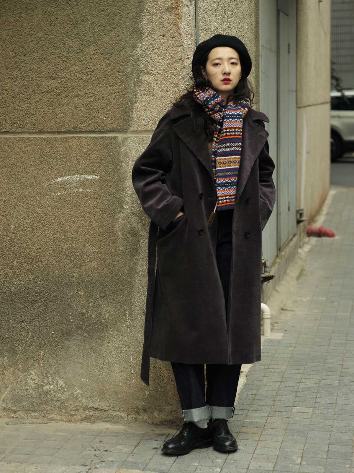 詳細画像：マフラーの織り目とフェアアイランド柄のディテールが鮮明に描かれており、シェトランドウール特有の柔らかな質感と耐久性が伝わります。染色技術にこだわったカラフルな糸が、アクセントとなる美しいデザインを際立たせています。

モデル画像：シェトランドウールのフェアアイランド柄マフラーを着用したモデルが、ヴィンテージ感のあるスタイルでコーディネートしています。マフラーの柔らかさと温かさが際立ち、日常的なカジュアルスタイルにもぴったりのアイテムであることを示しています。