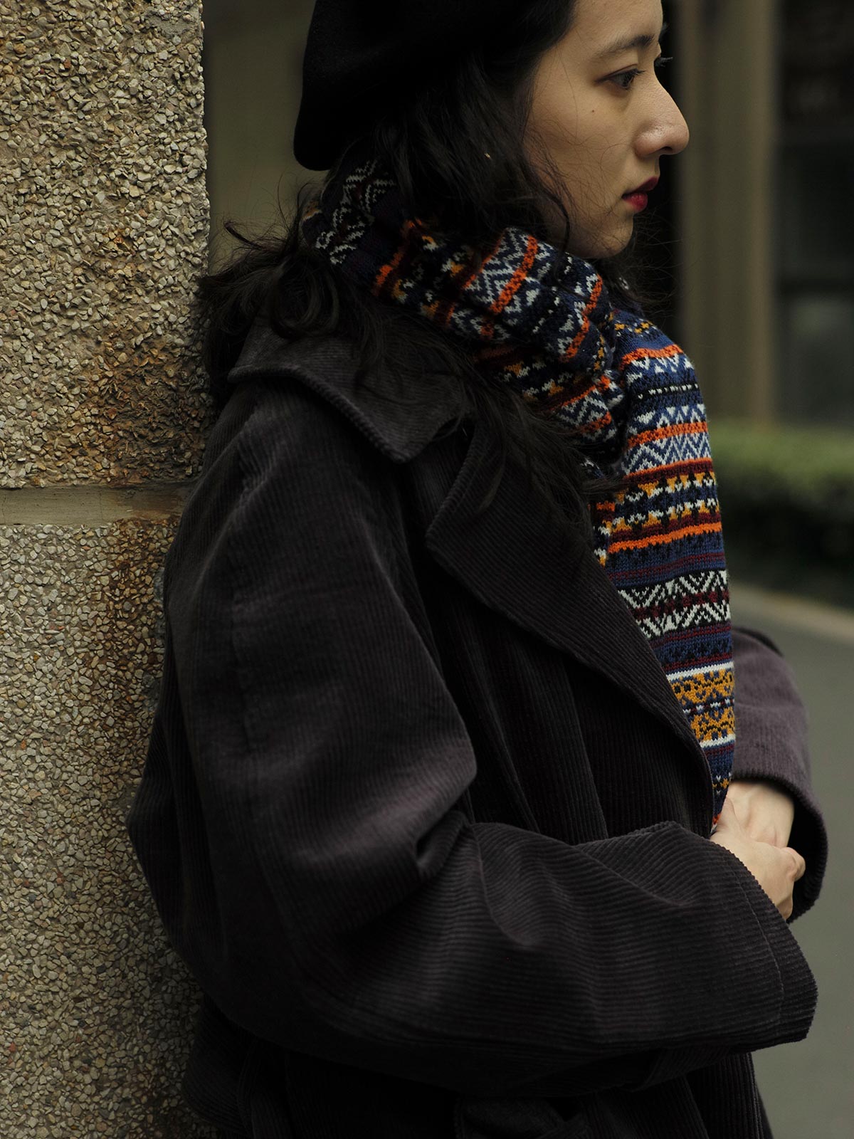 詳細画像：マフラーの織り目とフェアアイランド柄のディテールが鮮明に描かれており、シェトランドウール特有の柔らかな質感と耐久性が伝わります。染色技術にこだわったカラフルな糸が、アクセントとなる美しいデザインを際立たせています。

モデル画像：シェトランドウールのフェアアイランド柄マフラーを着用したモデルが、ヴィンテージ感のあるスタイルでコーディネートしています。マフラーの柔らかさと温かさが際立ち、日常的なカジュアルスタイルにもぴったりのアイテムであることを示しています。