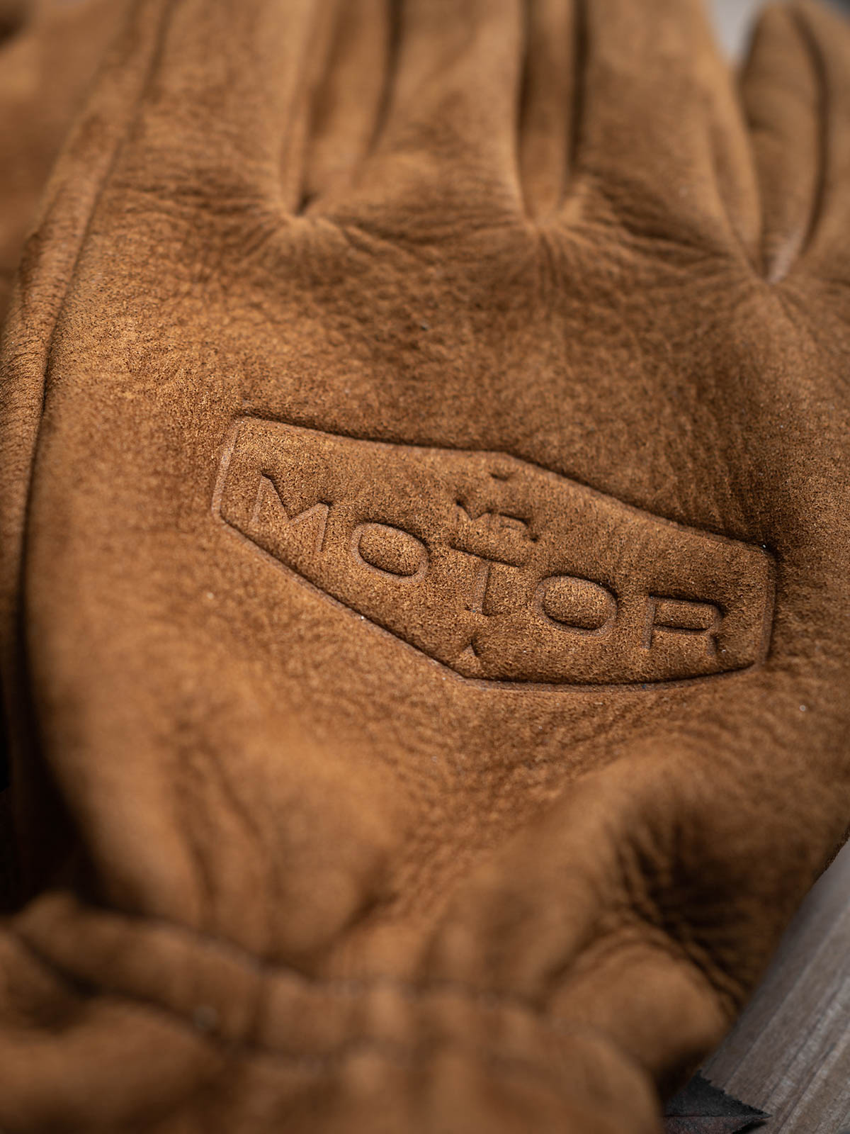 製品画像: ヴィンテージ風の磨き上げフルグレインレザーグローブの全体展示。優れた保温性と耐久性を持ち、アウトドアに最適なスタイル。
詳細画像: グローブのフルグレインレザーの質感とディテールが確認できる画像。ヴィンテージ感を持たせた加工が施され、長時間の使用でも快適な柔軟性を保持。