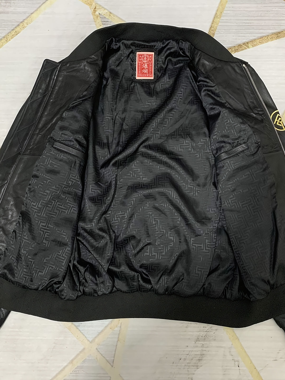 製品画像: 横須賀鶴図刺繍 羊革ジャケット全体画像、吉祥の象徴である「鶴図」刺繍と上質な輸入羊革のデザイン
詳細画像: 横須賀の伝統技法を用いた鶴、松、雲の刺繍ディテール、立体感ある精巧な工芸