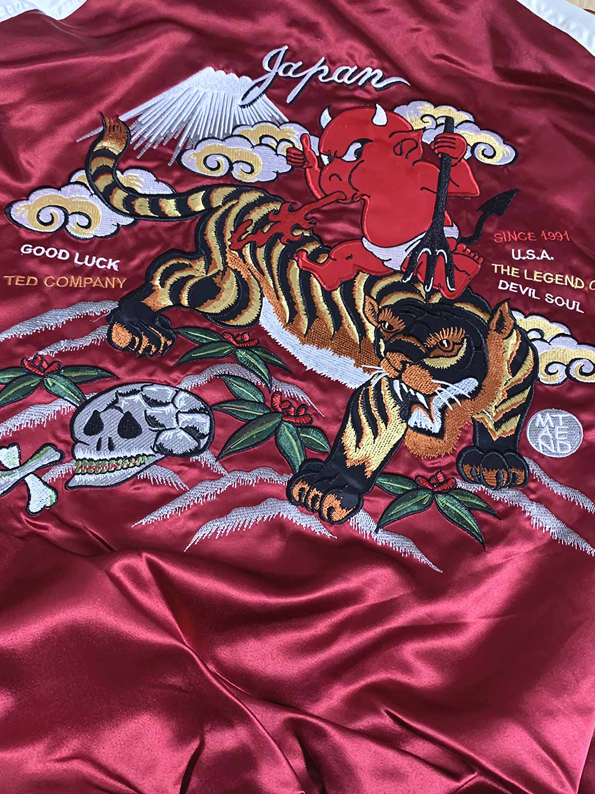 製品画像: リバーシブル シルク刺繍 横須賀 宝船 七福神 ジャケット全体画像、伝統的な横須賀刺繍と幸運の象徴デザイン

詳細画像: 七福神宝船と赤鬼、虎の刺繍ディテール、精緻なシルク刺繍で仕上げられた高級感あるデザイン