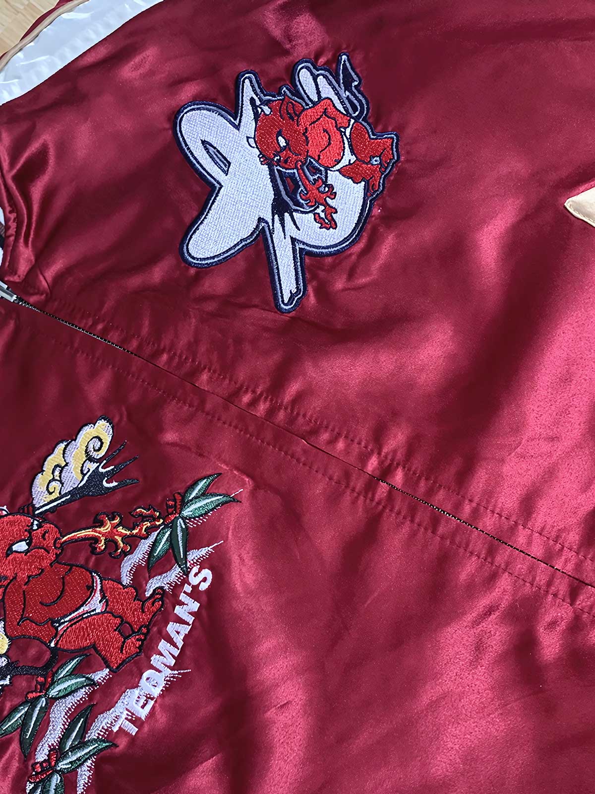 製品画像: リバーシブル シルク刺繍 横須賀 宝船 七福神 ジャケット全体画像、伝統的な横須賀刺繍と幸運の象徴デザイン

詳細画像: 七福神宝船と赤鬼、虎の刺繍ディテール、精緻なシルク刺繍で仕上げられた高級感あるデザイン