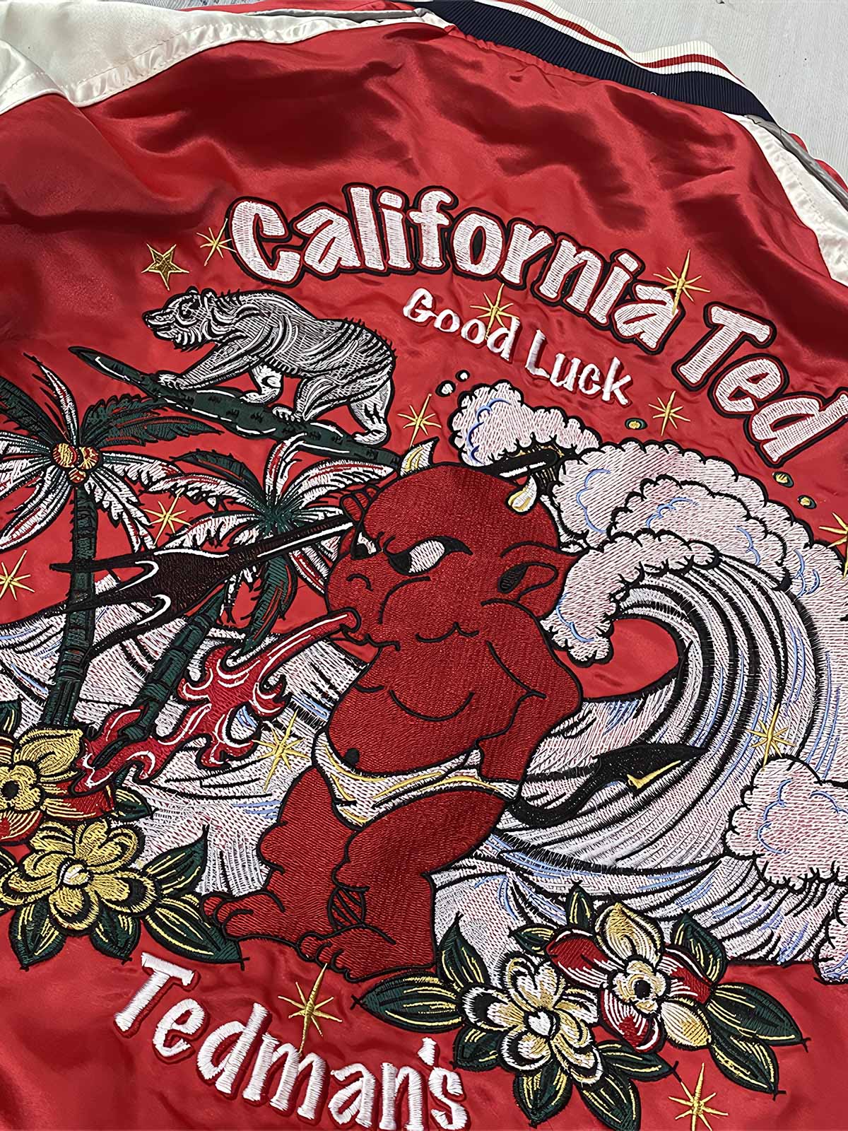 製品画像: リバーシブル シルク刺繍 横須賀 テッドマン 酒吞童子 ジャケットの全体画像、幸運を象徴する赤鬼と伝統的な刺繍デザイン

詳細画像: テッドマン（幸运の赤鬼）と酒吞童子の刺繍ディテール、横須賀刺繍の高度な技法で施されたアート
