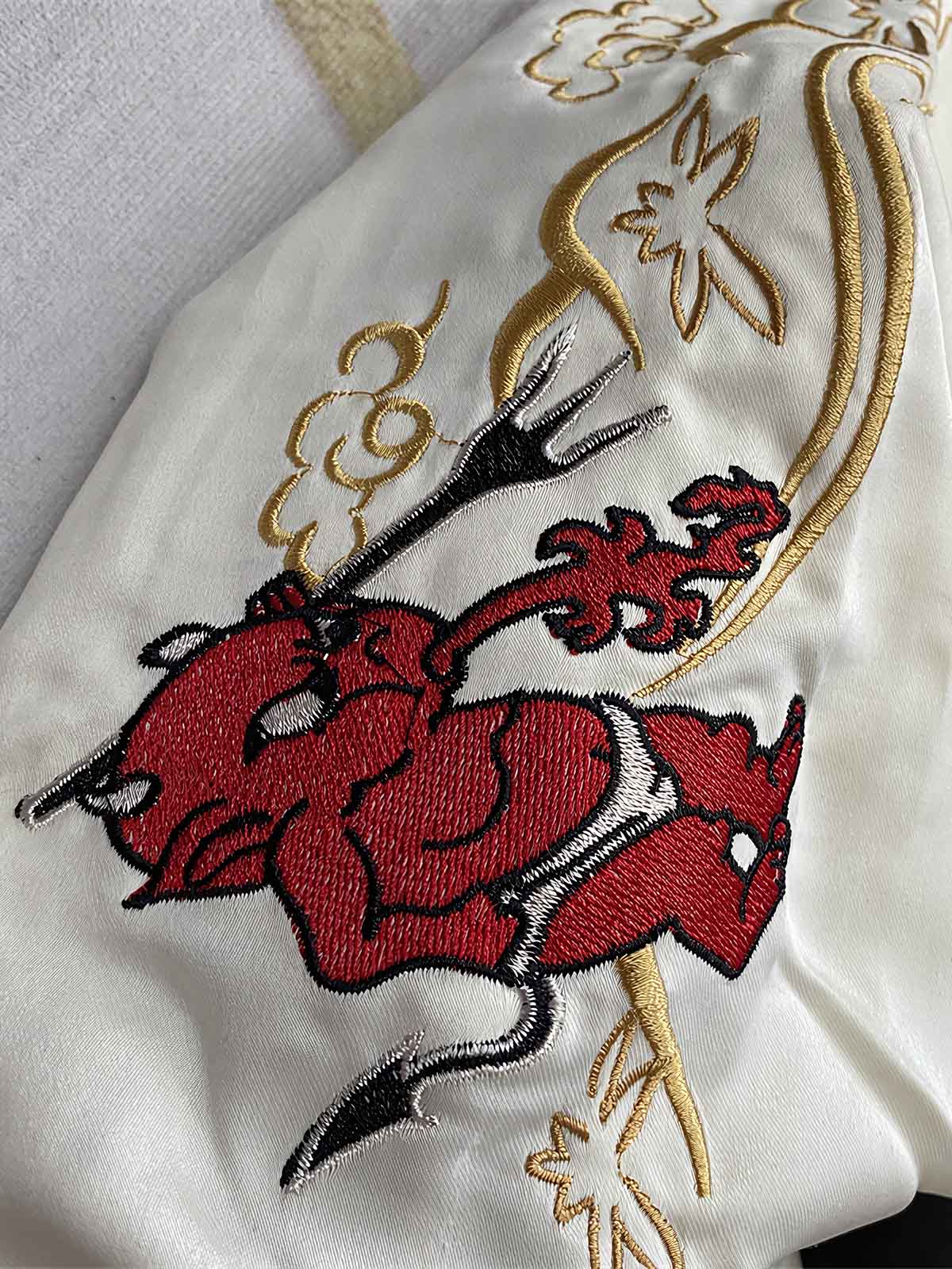 製品画像: リバーシブル シルク刺繍 横須賀 和柄タトゥーアートのシンガーとテッドマン ジャケットの全体画像、日本文化と個性の融合デザイン
詳細画像: 和柄タトゥーアートのシンガーとテッドマン（幸運の赤鬼）の刺繍ディテール、横須賀刺繍の精緻な美しさ