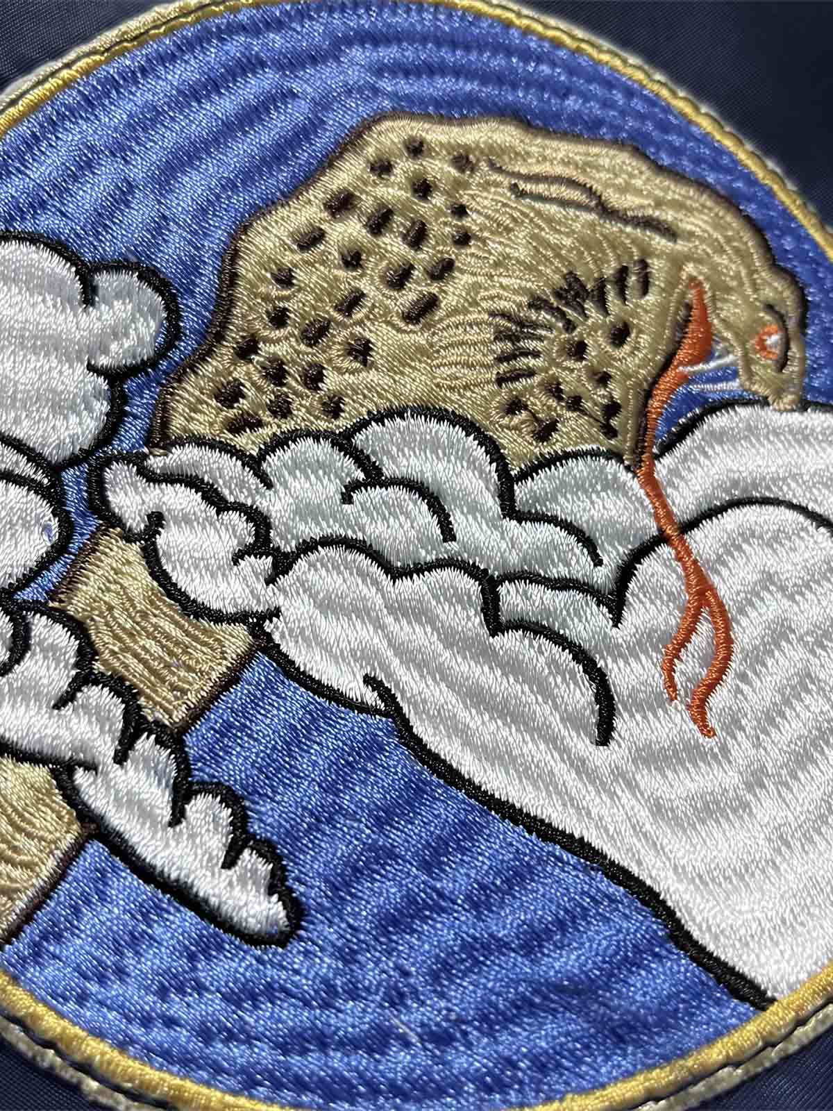 製品画像: 龍刺繍MA-1フライトジャケットの全体画像、防風・防水ナイロン素材を使用したクラシックなミリタリースタイル
詳細画像: 背面の龍刺繍と複数のミリタリーパッチのディテール、春秋向けの軽量デザイン