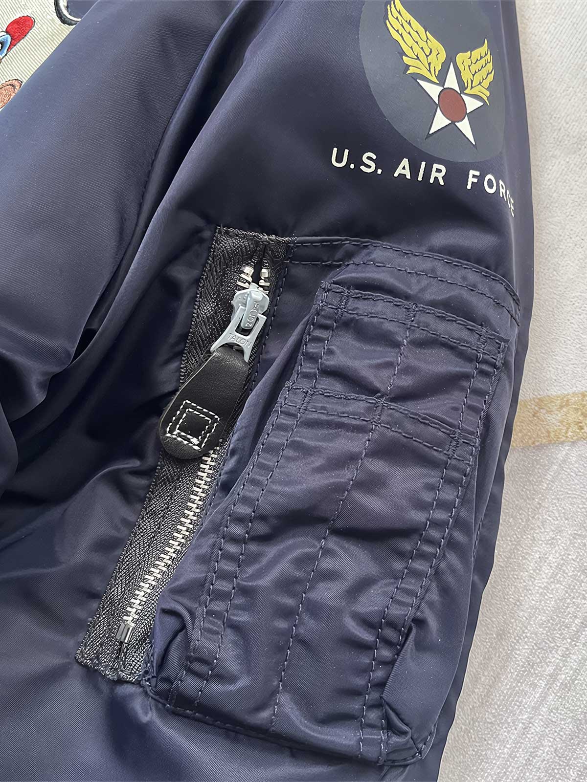 製品画像: Type L-2A複数の刺繍ワッペン付きフライトジャケットの全体画像、クラシックなアメカジミリタリースタイル
詳細画像: 胸元と袖に施された「U.S. Air Force」ワッペンや部隊エンブレム刺繍のディテール、ヴィンテージミリタリーテイストを強調