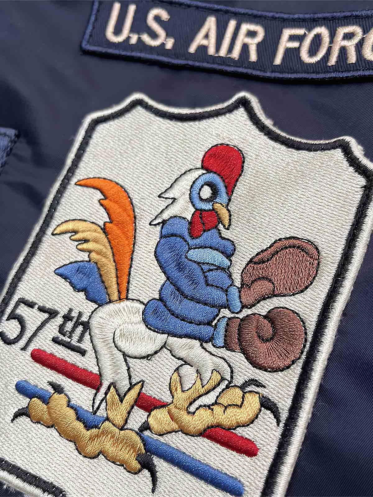 製品画像: Type L-2A複数の刺繍ワッペン付きフライトジャケットの全体画像、クラシックなアメカジミリタリースタイル
詳細画像: 胸元と袖に施された「U.S. Air Force」ワッペンや部隊エンブレム刺繍のディテール、ヴィンテージミリタリーテイストを強調