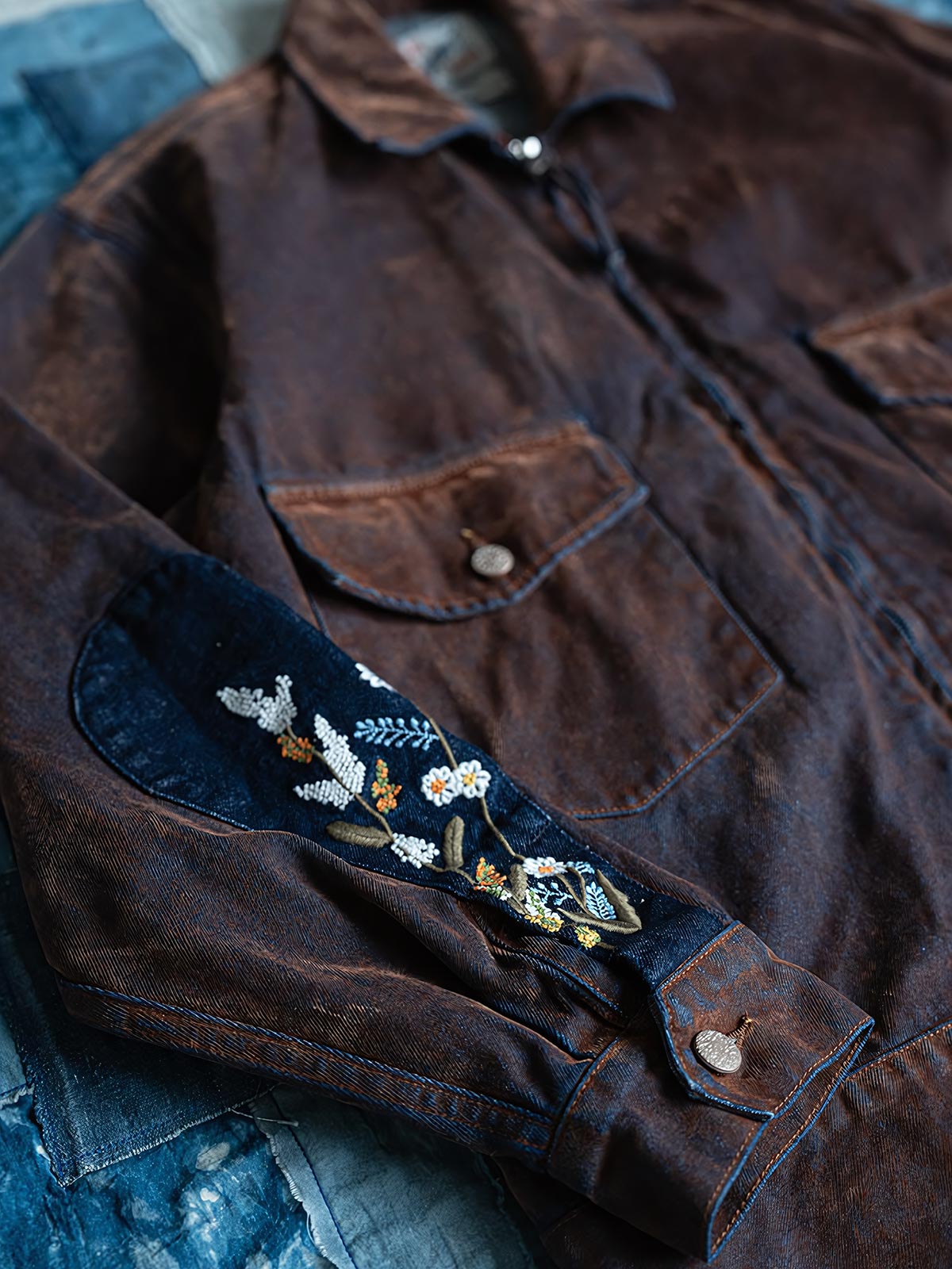 製品画像
レトロウォッシュ加工を施したワークジャケット。刺繍ディテールと多ポケットデザインが特徴的で、100%コットン素材を使用したアメリカンレトロスタイルのジャケット。

詳細画像
袖口の水滴刺繍パッチとフラップポケットデザインが特徴的なレトロウォッシュ加工ワークジャケットのディテール。