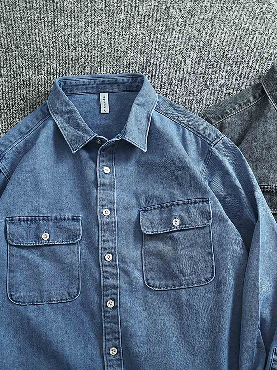 製品画像:
ヴィンテージウォッシュ加工のデニムシャツの正面画像。自然な風合いとカジュアルなスタイルが特徴で、日常使いにぴったり。

詳細画像:
シャツのワークポケットとウォッシュ加工のディテールをクローズアップ。生地感とデザインの細部がよく見えるように撮影されています。