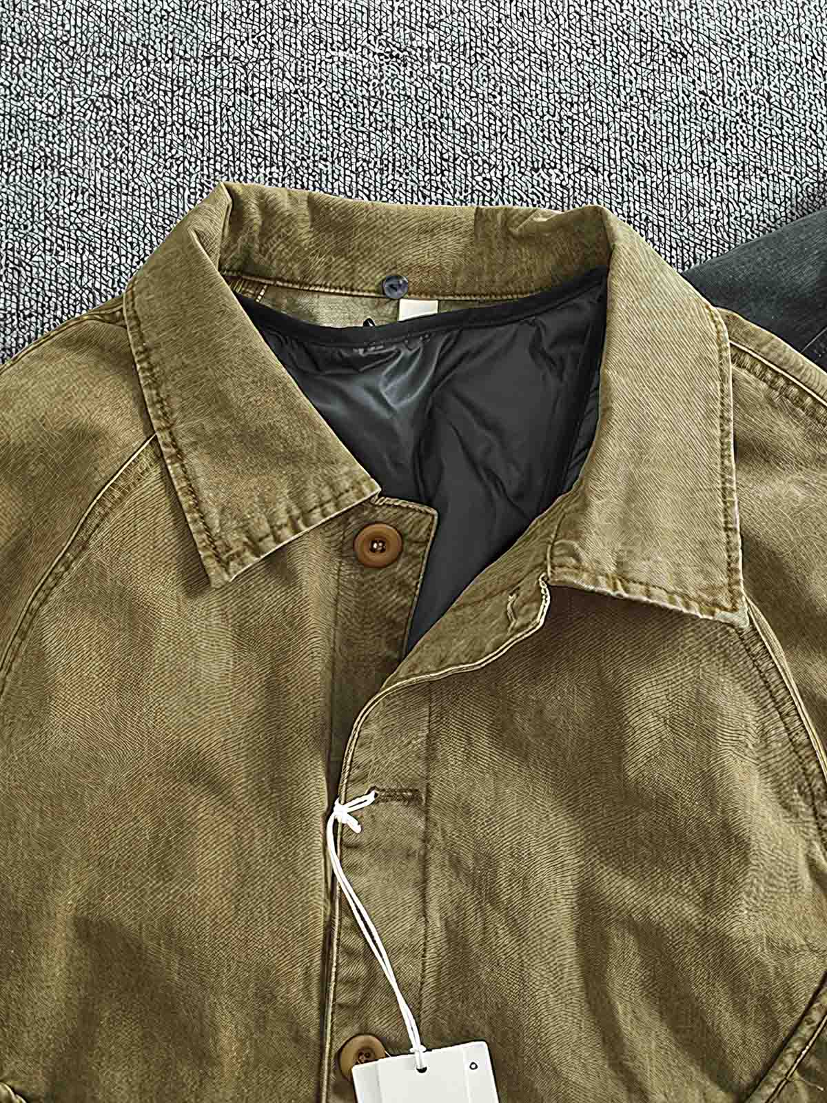 製品画像
取り外し可能なダウンインナー付きワークジャケット全体展示。ウォッシュ加工されたコットン生地が際立ち、ヴィンテージ感を強調しています。シンプルでシックなデザインが特徴。
詳細画像
ウォッシュ加工されたコットン生地とダウンインナーのディテールアップ。取り外し可能なダウンインナーのジッパーデザインと素材感がしっかりと見える。