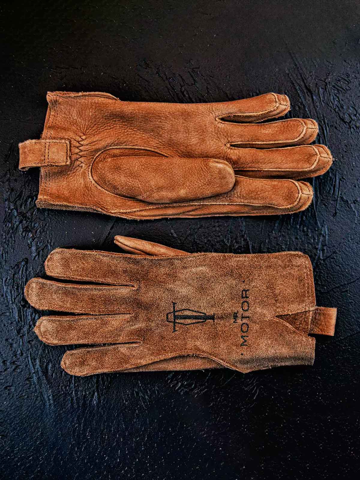 製品画像
マットレザーのバイカーズグローブ全体展示。バイカーズグローブ特有の硬派で無骨なデザインが際立ち、ライディングに最適な機能性を持ち合わせています。ヴィンテージ感のあるレザーが、長年の使用でさらに味わい深く変化する点が特徴です。
詳細画像
グローブのディテールと素材感アップ。マットレザーを使用した手袋の細部が強調されており、特にダブルステッチや鷲の目のデザインが、製品の耐久性と独特な個性を引き立てています。手に馴染む柔らかな質感や、ヴィンテージの風合いが美しく表現されています。