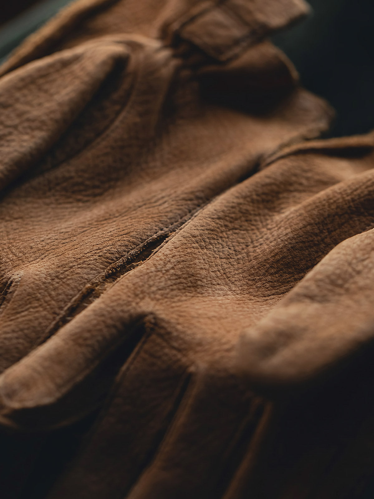 製品画像
マットレザーのバイカーズグローブ全体展示。バイカーズグローブ特有の硬派で無骨なデザインが際立ち、ライディングに最適な機能性を持ち合わせています。ヴィンテージ感のあるレザーが、長年の使用でさらに味わい深く変化する点が特徴です。
詳細画像
グローブのディテールと素材感アップ。マットレザーを使用した手袋の細部が強調されており、特にダブルステッチや鷲の目のデザインが、製品の耐久性と独特な個性を引き立てています。手に馴染む柔らかな質感や、ヴィンテージの風合いが美しく表現されています。