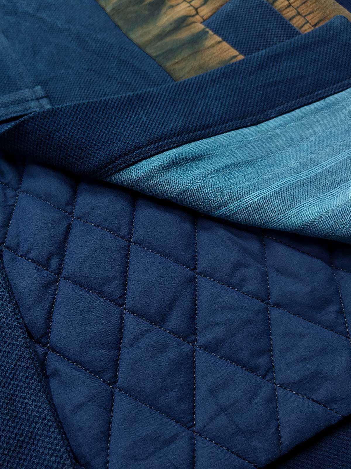 製品画像
植物藍染ピンチワークはんてんの全体展示。藍染めとピンチワークのデザインが際立ち、東洋的な風情が感じられるアイテム。冬のコーディネートにぴったりの暖かさとレトロスタイルが魅力です。

詳細画像
藍染ピンチワークとコットン入りのディテール画像。藍染め手織り布とピンチワークの細部が強調され、色合いや質感が鮮明に表現されています。商品の特徴を深く理解できる一枚です。