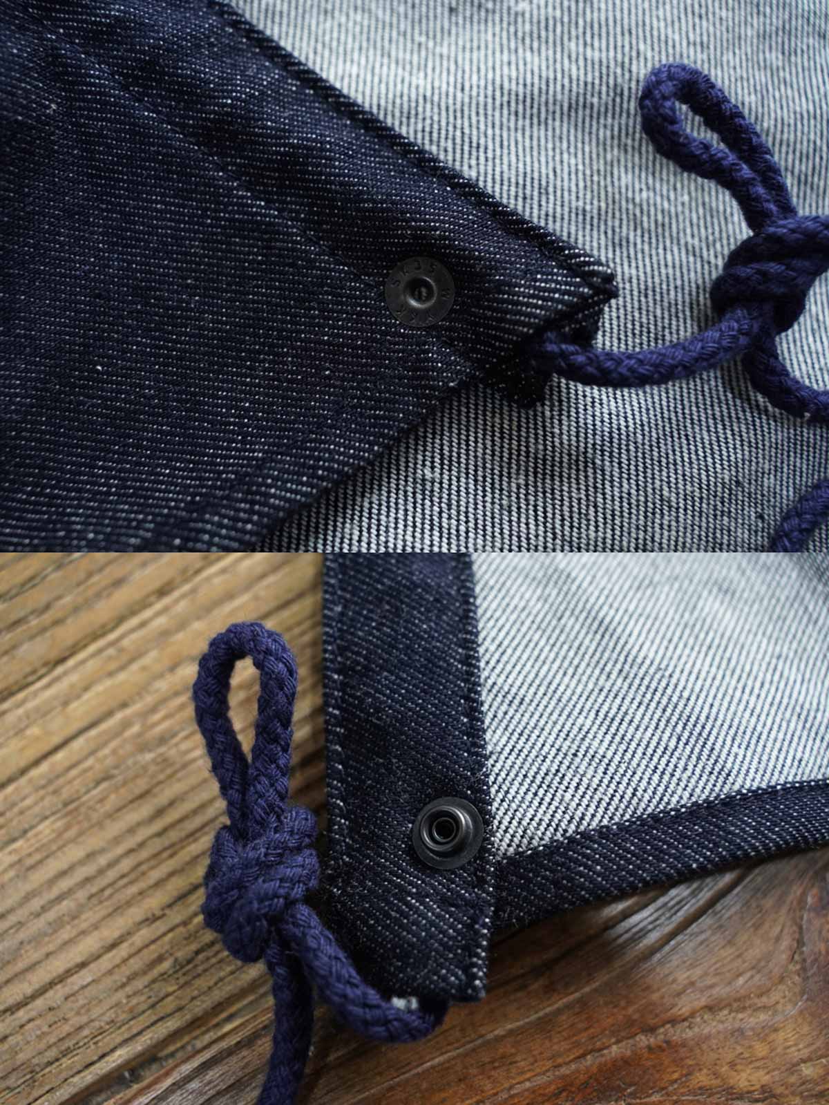 製品画像： デニムバージョンのM51フィッシュテールコート全体イメージ画像。特注のデニム素材で再現されたヴィンテージミリタリースタイルが特徴的。シルバーカラージッパーやブルー樹脂ボタンなど、細部までこだわったデザインが魅力。
詳細画像： YKK製スナップボタンと特注シルバーカラージッパー、ブルー樹脂ボタンのディテールをクローズアップした画像。ヴィンテージ感を引き立てる丁寧なディテールが際立つ。