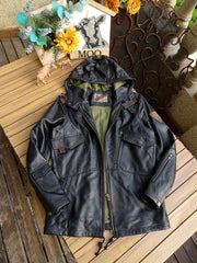 製品画像： 9ポケットフィールドフード付きフルグレインレザージャケット全体イメージ画像。黒いシボ加工レザーとヴィンテージ感漂うオイル仕上げのスエードディテールが特徴で、アウトドアやバイクライドにも適した多機能デザイン。
詳細画像： YKKアンティークブロンズジッパーとオイルドスエードレザーの補強ディテールをクローズアップした画像。耐久性とクラシックな風合いが際立つ仕上がり。