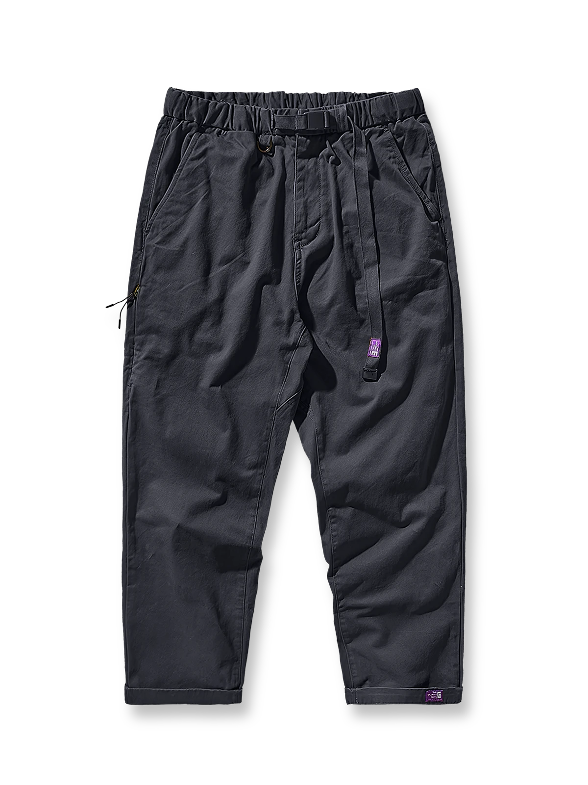 製品画像：紫タグが付いたワーク テーパードパンツの全体像。高品質な純銅YKKジッパーや金属ボタン、そしてしっかりとしたテーパードシルエットが際立ち、スタイリッシュで実用的なデザインが特徴のパンツを全体的に見せる展示画像。

詳細画像：紫タグが強調されたバックルベルトと隠しワークポケットのディテールクローズアップ。バックルベルト部分の調節機能と隠しポケットのディテールが、実用性とデザイン性を兼ね備えた特徴を詳しく見せる画像。