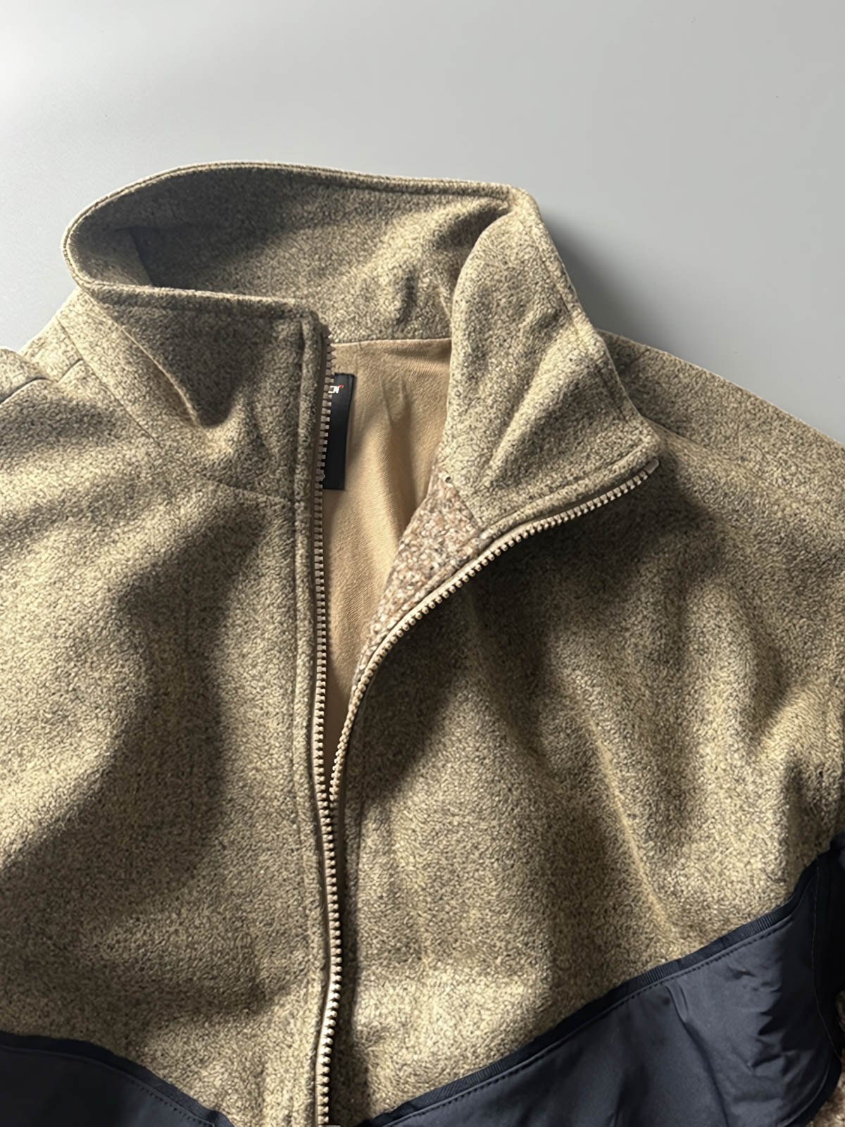 製品画像
ウール混紡パッチワークジャケットの全体展示図。立ち襟デザインとレトロなジオメトリックパターンが特徴の秋冬にぴったりなジャケット。

詳細画像
パッチワークジオメトリックパターンと立ち襟のディテールクローズアップ。素材の異なる部分が織りなす視覚的なレイヤリング効果を強調。