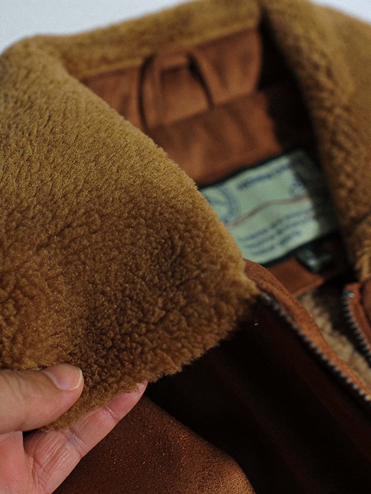 製品画像代替テキスト
フェイクスエード裏起毛ハンティングジャケット、アメリカンヴィンテージスタイルのデザイン。シープスキンライニングとフェイクムートン襟が特徴の秋冬アウター。カーキやブラックのカラー展開。

詳細画像代替テキスト
フェイクスエード裏起毛素材とシープスキンライニングのディテール。フェイクムートン襟とリブ編みの裾、ヴィンテージ感漂うデザイン。機能性とデザイン性を兼ね備えた大きなフラップポケット。
