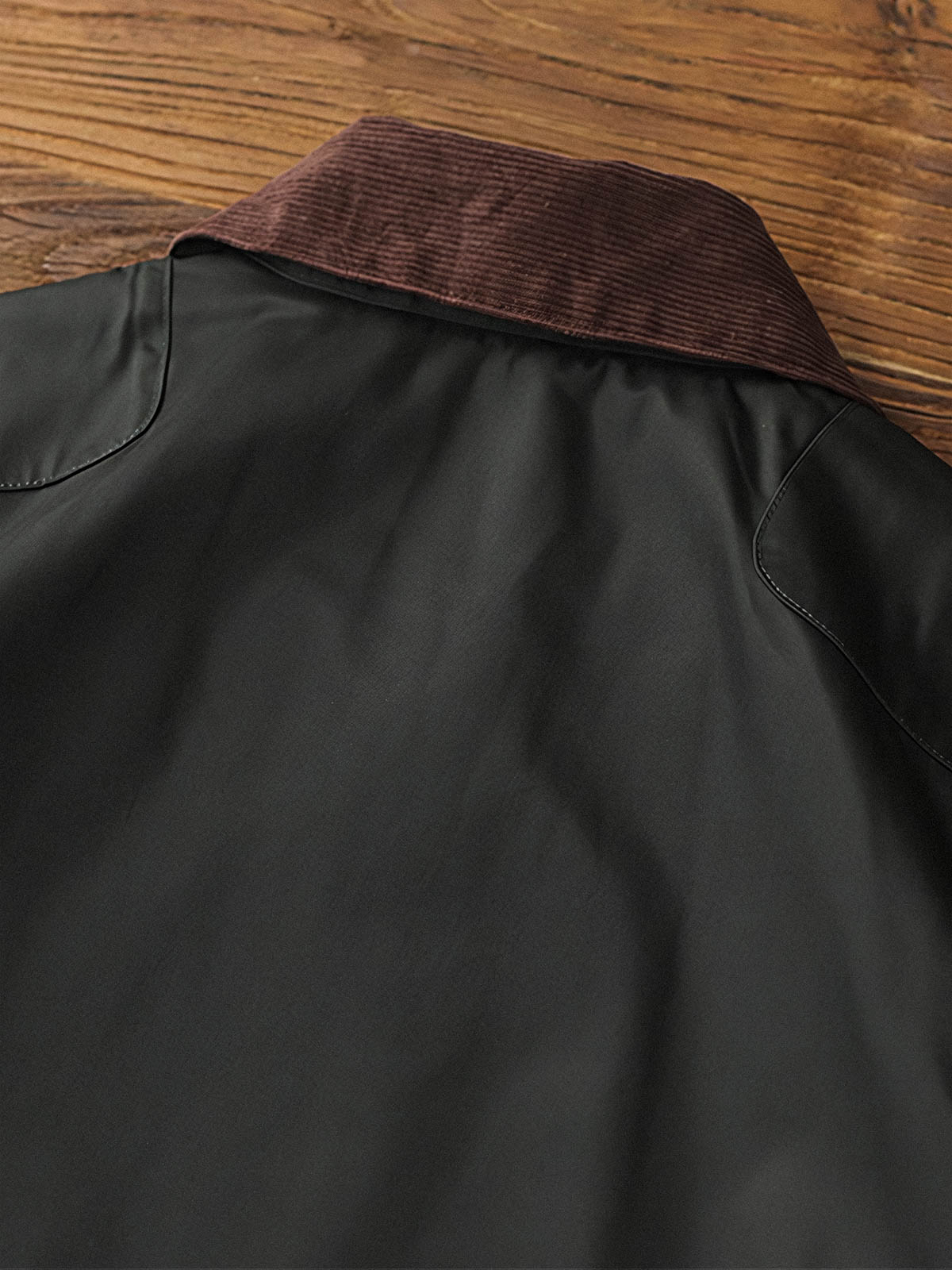 製品画像: コーデュロイカラーのコントラスト襟とオイルワックス加工が施されたハンティングジャケット。高密度梭織生地を使用し、耐久性とレトロ感を兼ね備えたデザイン。

詳細画像: チェック柄のキルティングライニングとスナップボタン付き風防襟のディテール。YKKのダブルヘッドラウンドリングジッパーと多機能ポケット配置が実用性を高めています。