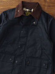 製品画像: コーデュロイカラーのコントラスト襟とオイルワックス加工が施されたハンティングジャケット。高密度梭織生地を使用し、耐久性とレトロ感を兼ね備えたデザイン。

詳細画像: チェック柄のキルティングライニングとスナップボタン付き風防襟のディテール。YKKのダブルヘッドラウンドリングジッパーと多機能ポケット配置が実用性を高めています。