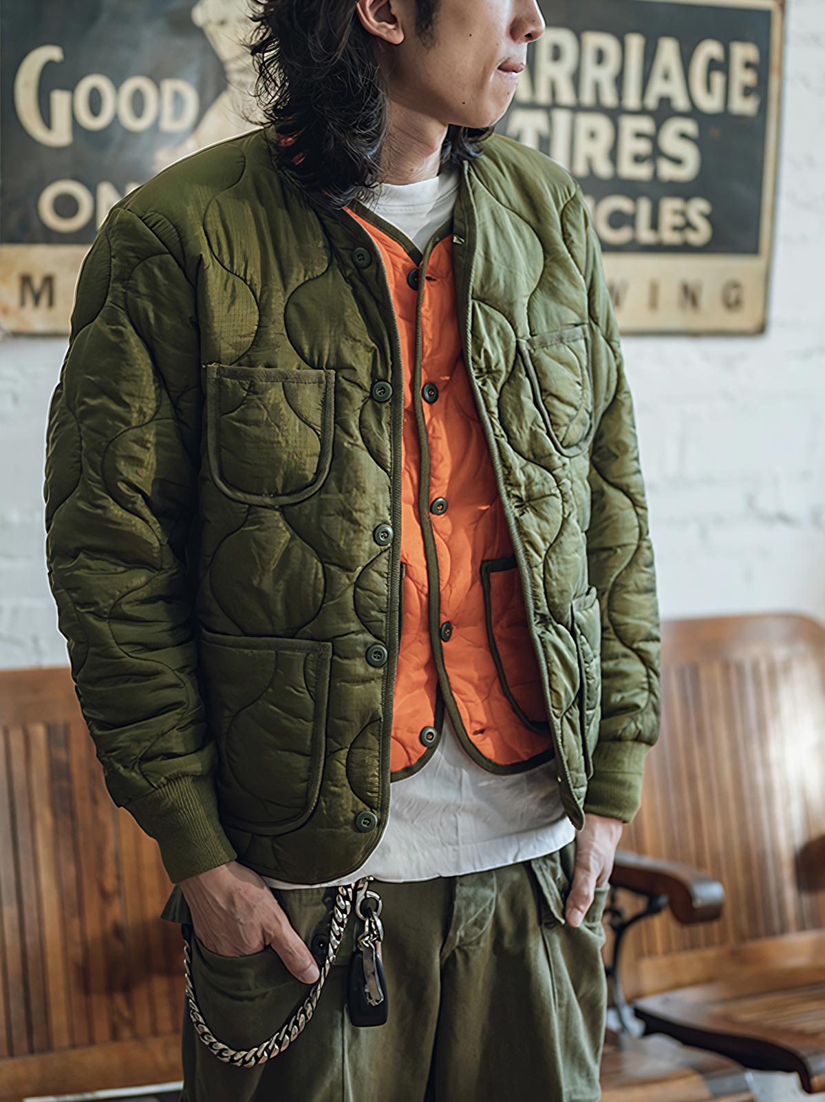 詳細画像: リバーシブルデザイン（オリーブグリーンとレスキューオレンジ）、袖口のリブ編みが冷気をシャットアウト。軽量でありながら優れた保温性を提供。

モデル画像: モデルが弧形キルティングインナーダウンジャケットを着用、ルーズフィットシルエットと防水性に優れた素材で、秋冬のレイヤードスタイルを演出。