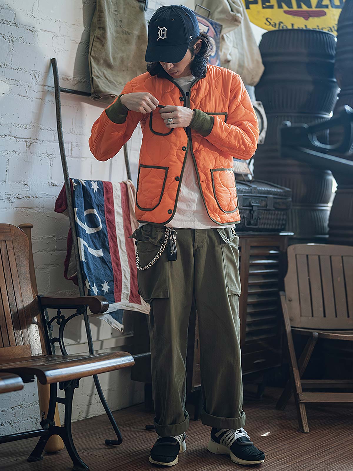 詳細画像: リバーシブルデザイン（オリーブグリーンとレスキューオレンジ）、袖口のリブ編みが冷気をシャットアウト。軽量でありながら優れた保温性を提供。

モデル画像: モデルが弧形キルティングインナーダウンジャケットを着用、ルーズフィットシルエットと防水性に優れた素材で、秋冬のレイヤードスタイルを演出。