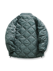 製品画像: 波型キルティングデザインの中綿ジャケット正面展示図、シンプルでスタイリッシュなデザインを強調。

詳細画像: 波型キルティングとダウンライクファイバー充填のディテールクローズアップ、優れた保温性とデザインを強調。