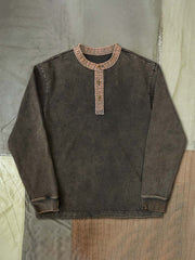 製品画像: ハードウォッシュ加工でヴィンテージ感を演出した植物染めのヘンリーネック長袖Tシャツ。コントラストカラーのフリンジデザインがアクセントとなり、独特な質感を演出。

詳細画像: 厚手で耐久性のある300gダブル糸コーマコットンニットを使用。植物染めによる色合いとフリンジデザインがヴィンテージ感を高める。