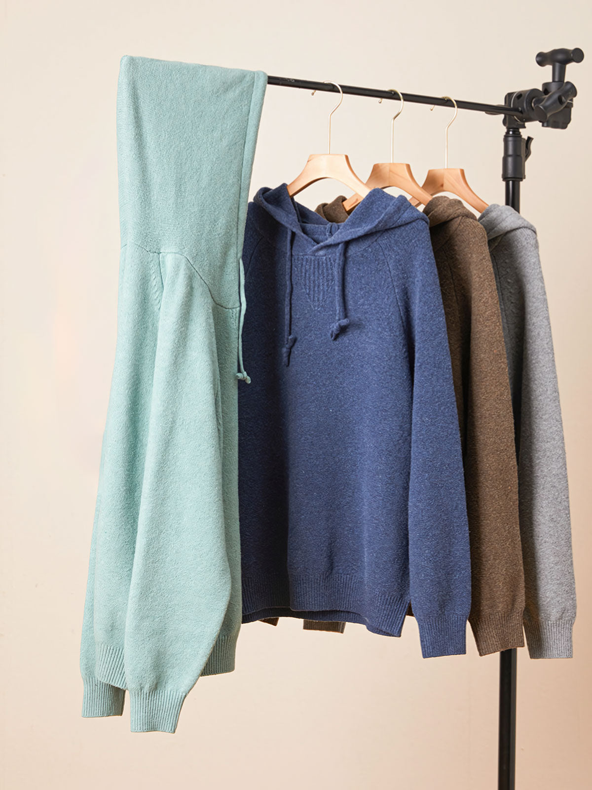 製品画像
ウール混紡フード付きニットセーター全体図。シンプルなフードデザインと厚みのある5ゲージ編みが特徴で、起毛加工により柔らかな肌触りを実現した中厚ニットセーター。ブルー、コーヒー、グレー、グリーンの4色展開。

詳細画像
裾のリブ編みデザイン、袖口の耐久性強化ディテール、フードのドローストリング仕様、起毛加工が施された高品質なウール混紡素材、5ゲージ9本取り編みの質感特写。